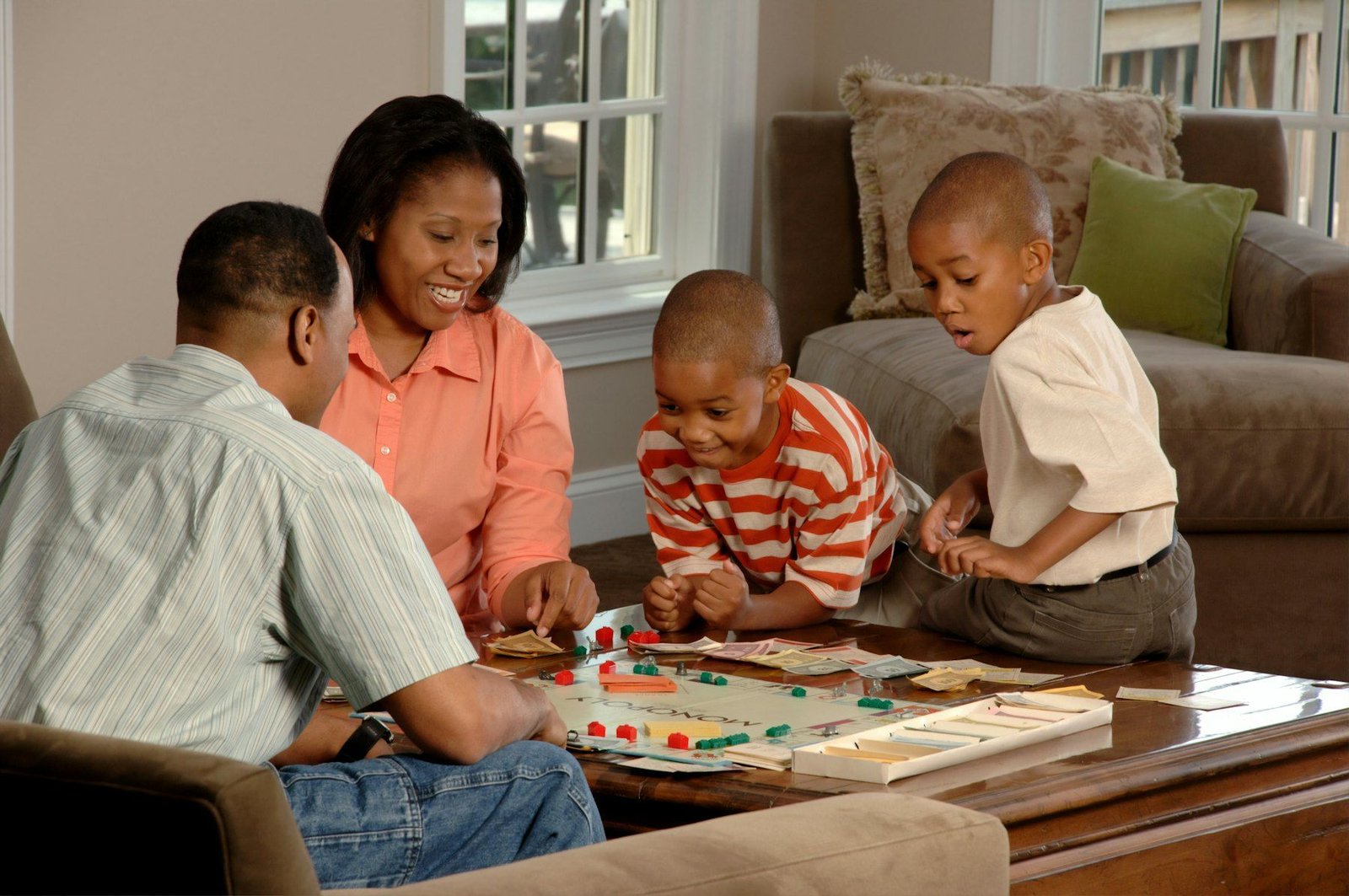 Une famille joue à un jeu de société au salon