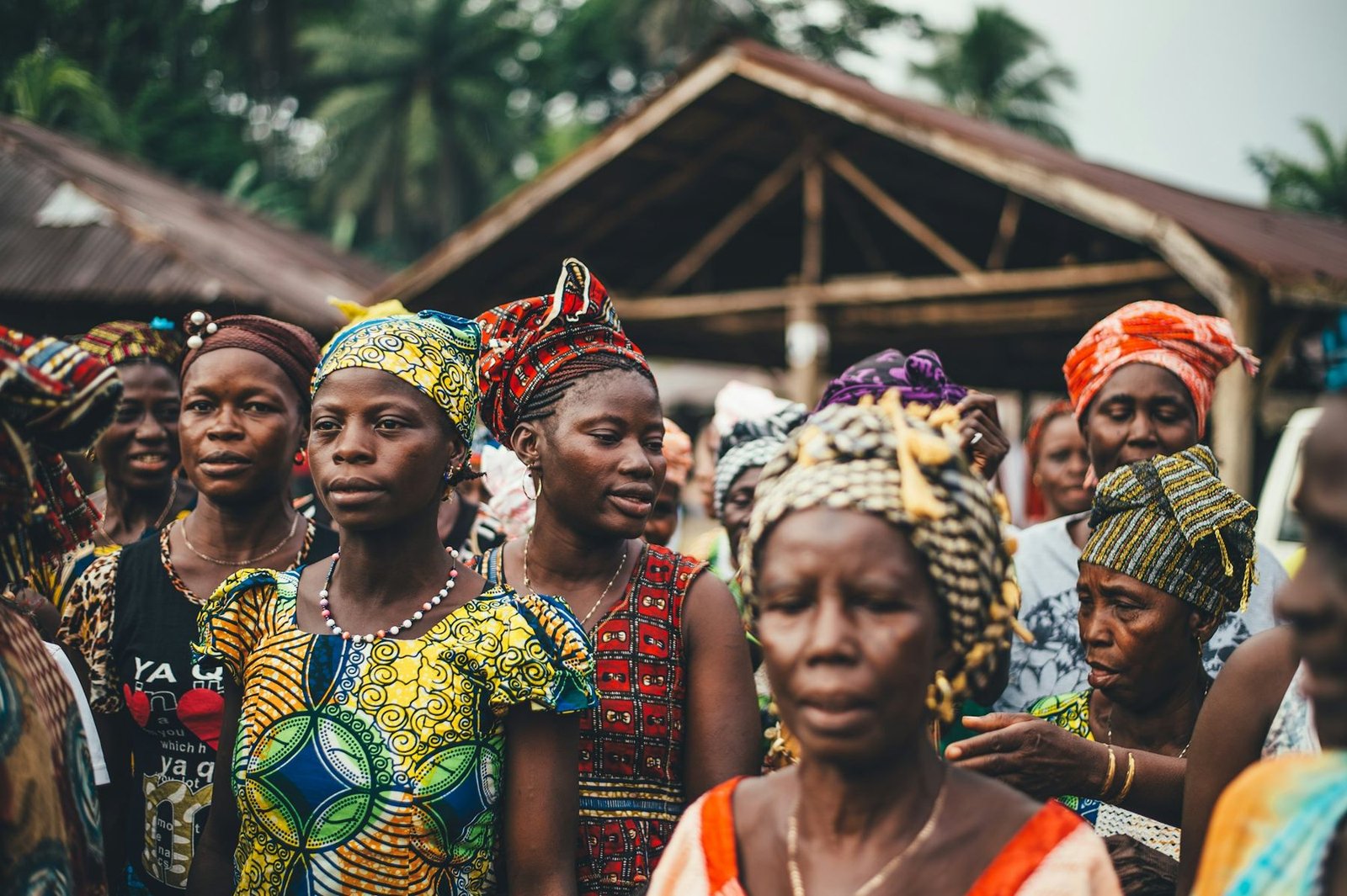 Village women gathered in front of a thatched hut